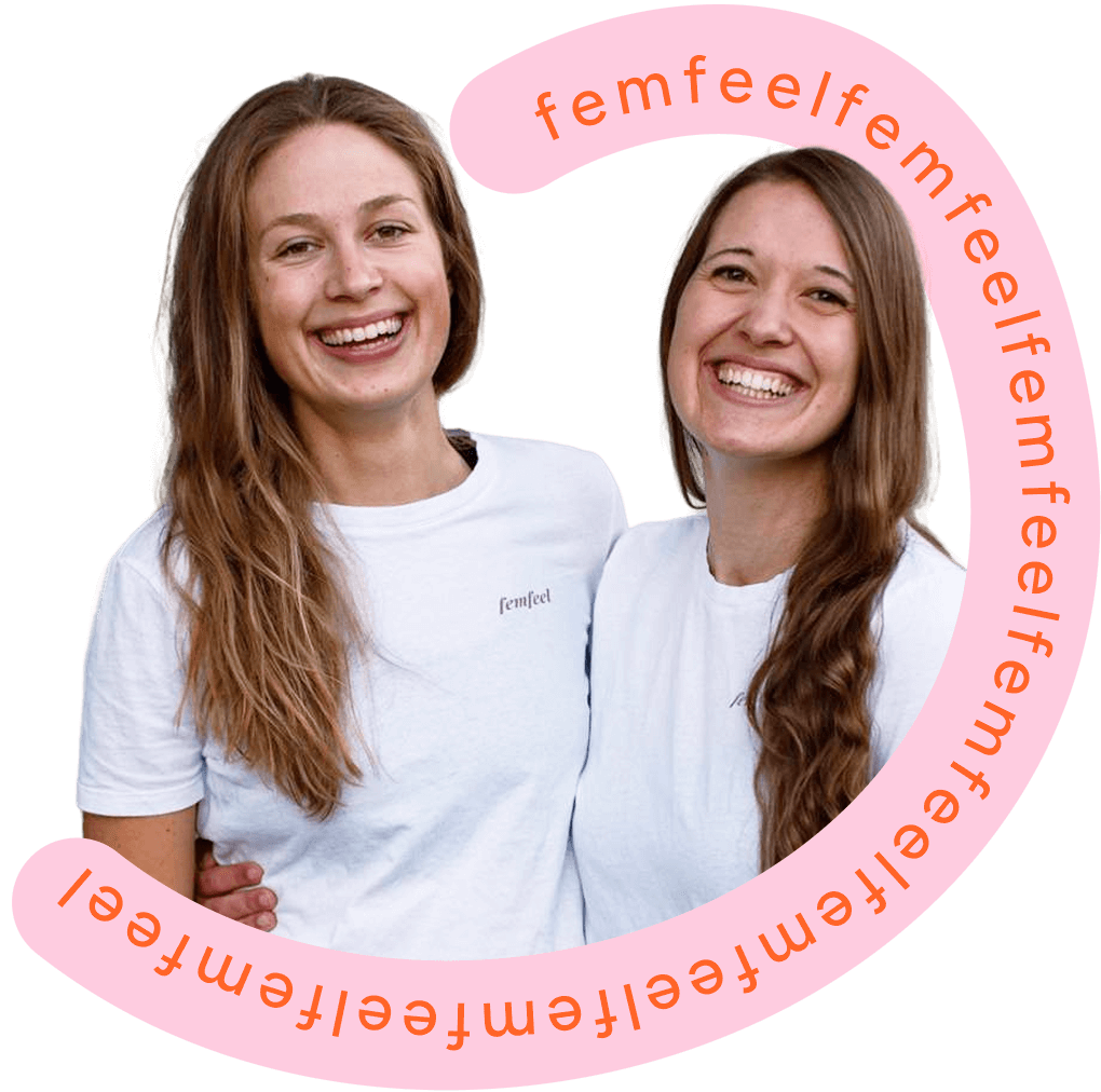 Die zwei femfeel Gründerinnen lachen gemeinsam in weißen femfeel T-Shirts.